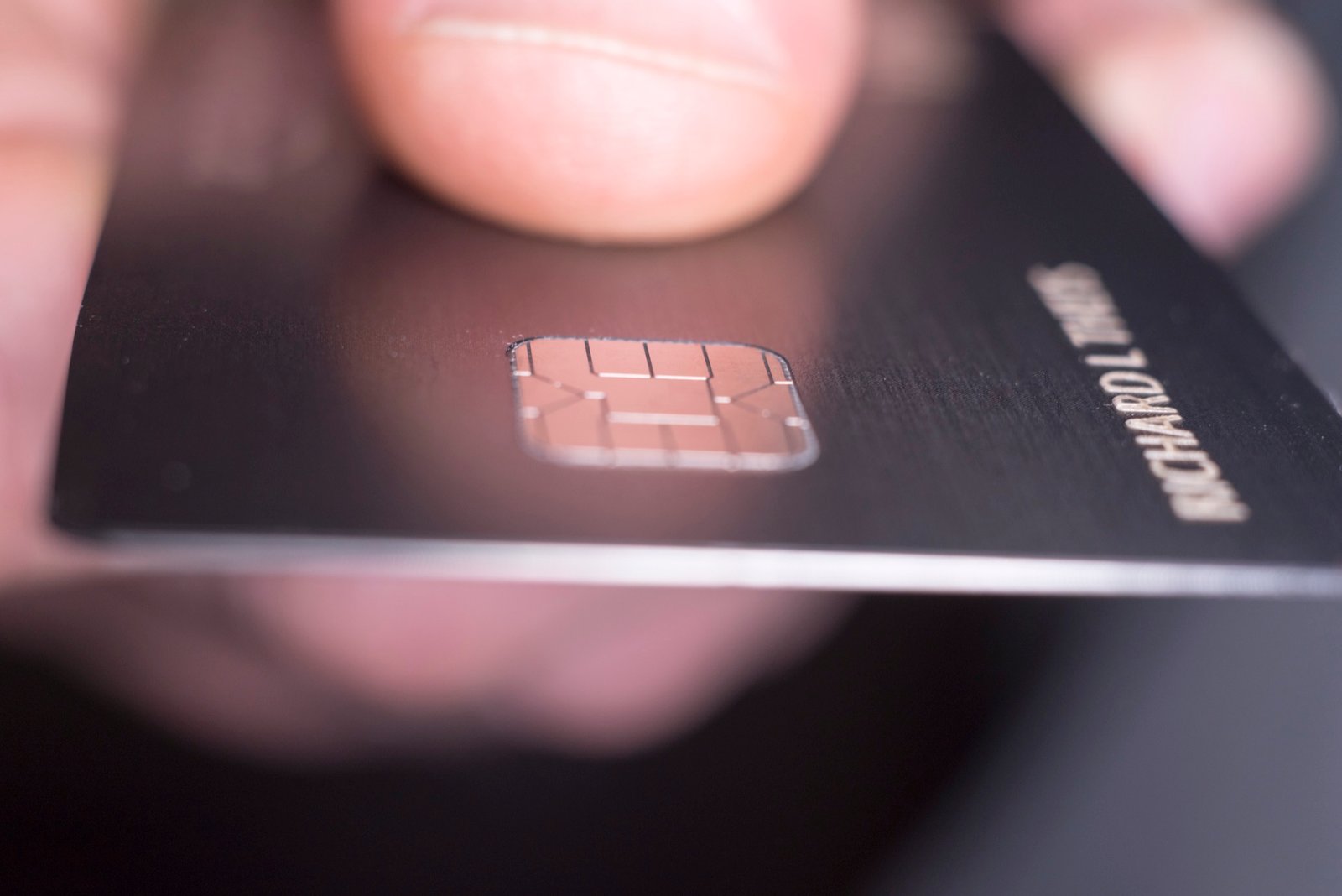 A payment card held close, chip in focus